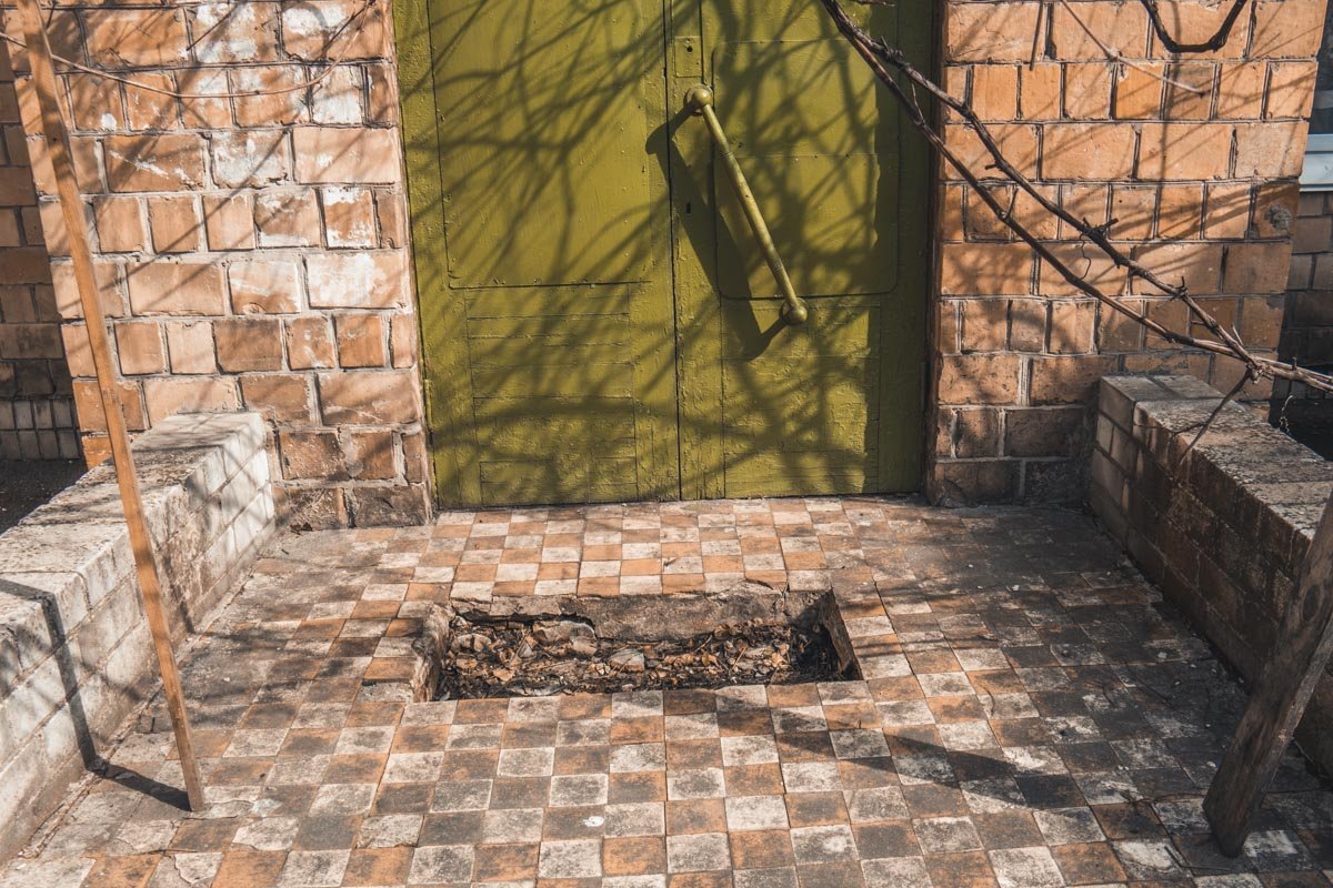 Дыра в полу возле входа в здание