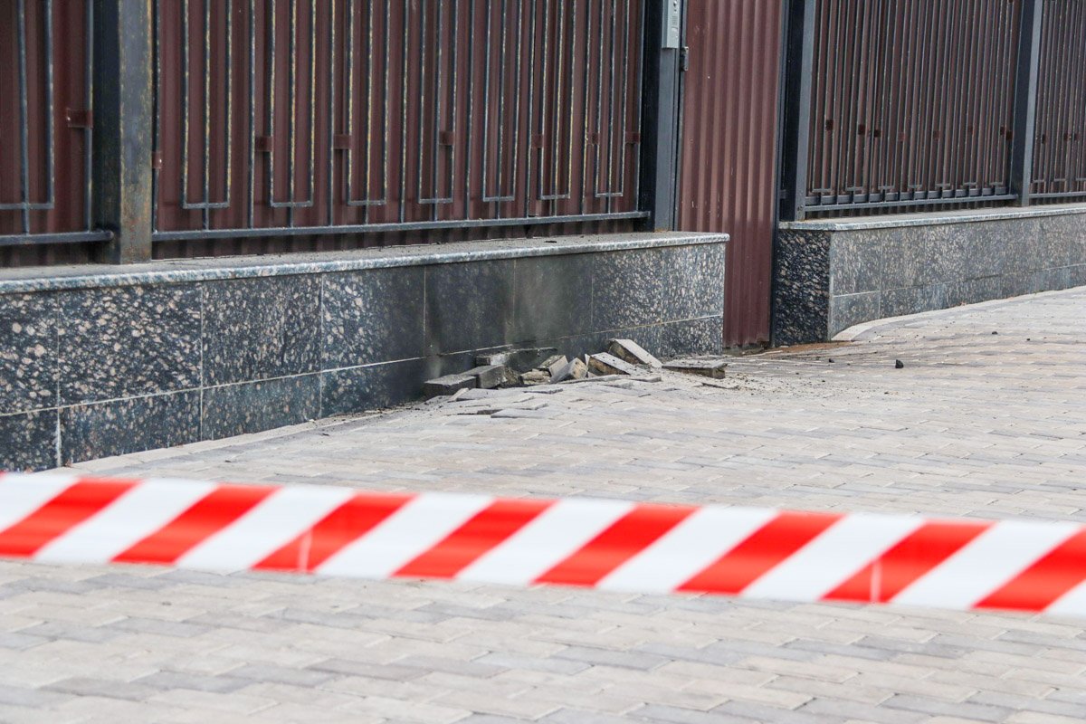 В результате взрыва была повреждена тротуарная плитка и появилось черное пятно на заборе В результате взрыва была повреждена тротуарная плитка и появилось черное пятно на заборе