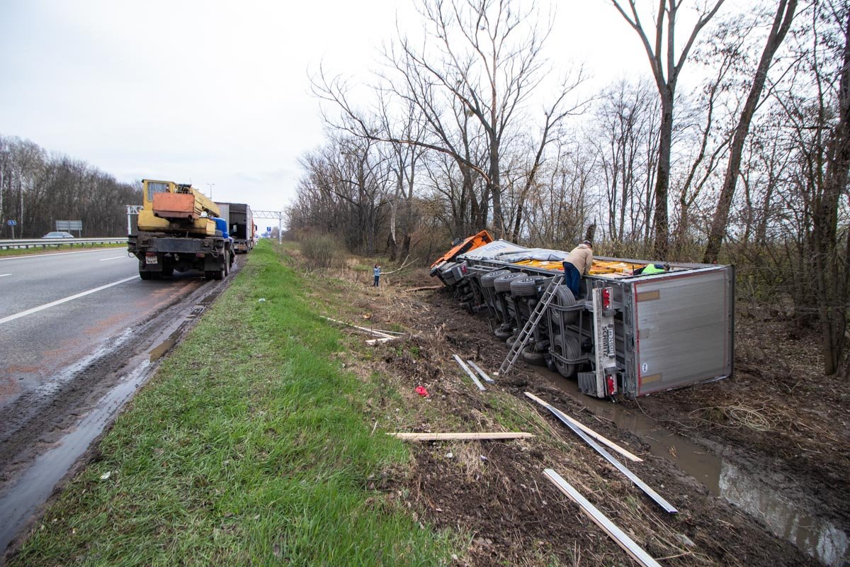 Грузовик разгружают рабочие для того, чтобы авто можно было поднять Грузовик разгружают рабочие для того, чтобы авто можно было поднять