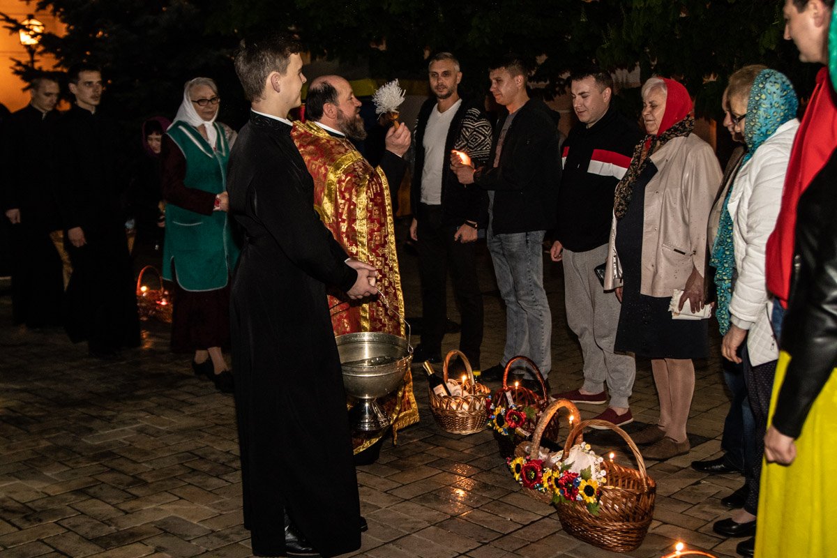 Священнослужитель освящает пасхальные корзины прихожан