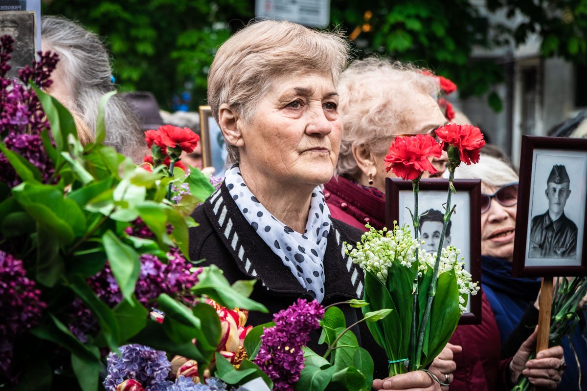 Люди прошли маршем памяти к Парку Вечной Славы, держа в руках фотографию родственника - участника Второй мировой войны Люди прошли маршем памяти к Парку Вечной Славы, держа в руках фотографию родственника - участника Второй мировой войны