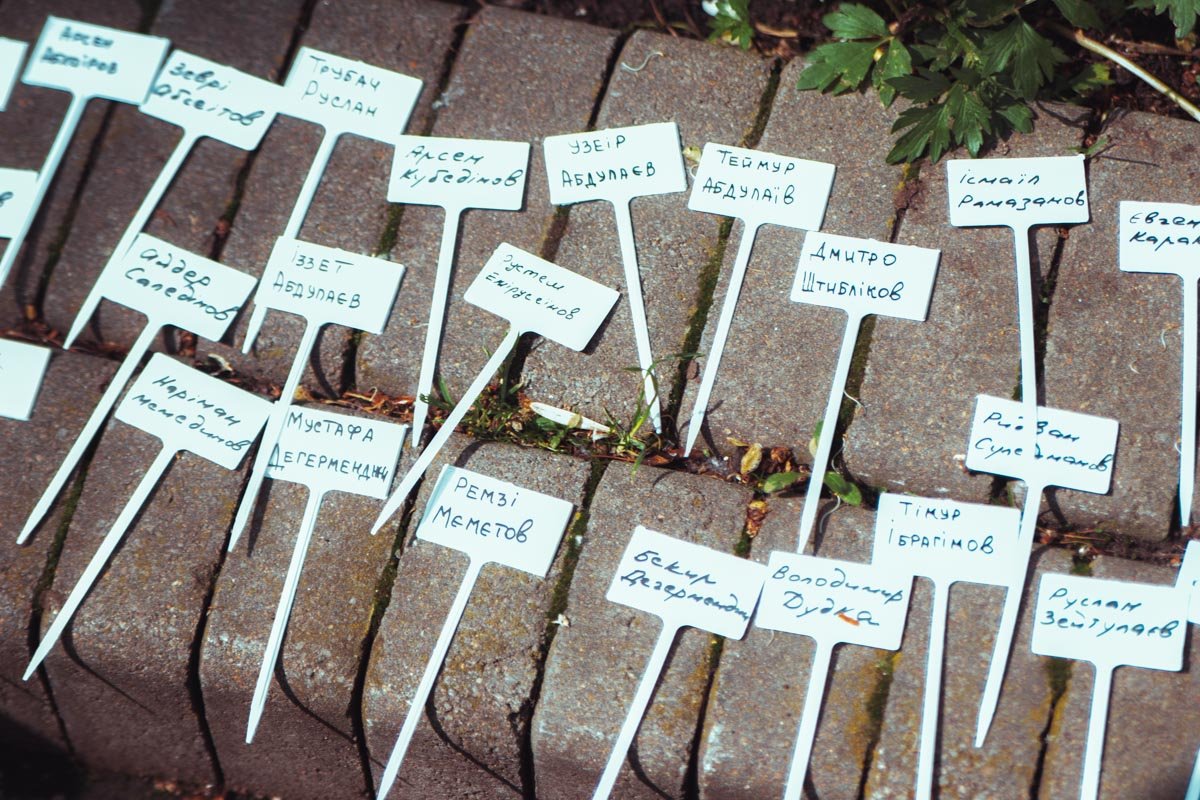 Возле саженцев разместили маленькие таблички с именами заложников Кремля