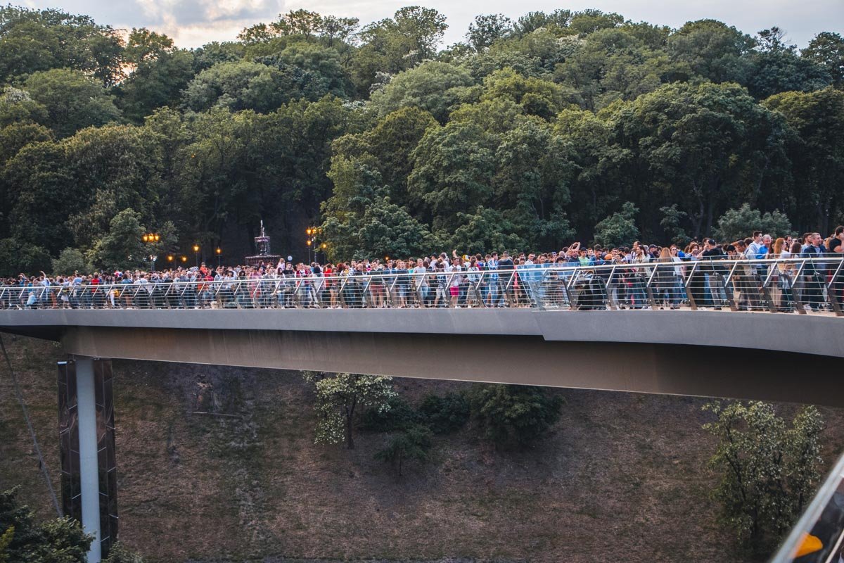 Заполненный людьми пешеходно-велосипедный мост Заполненный людьми пешеходно-велосипедный мост