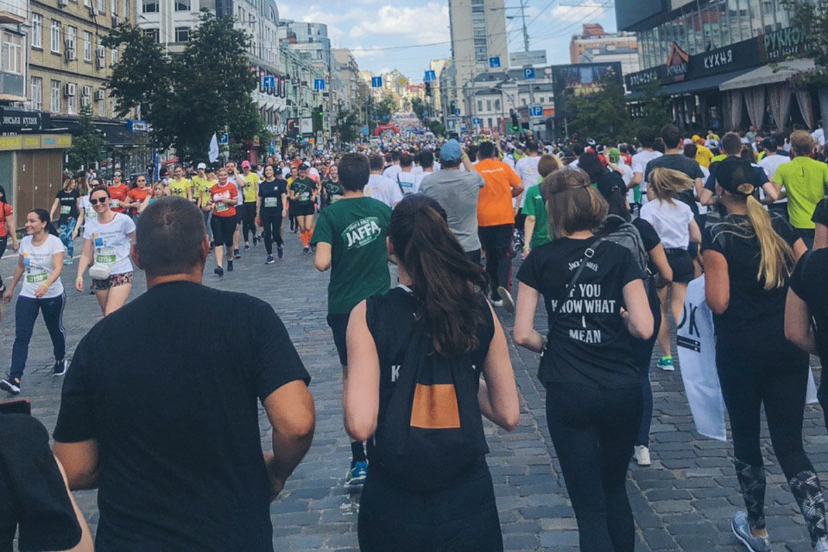 Участники поддерживают друг друга, делятся водой, некоторые помогают и подбадривают тех, кто устал и остановился