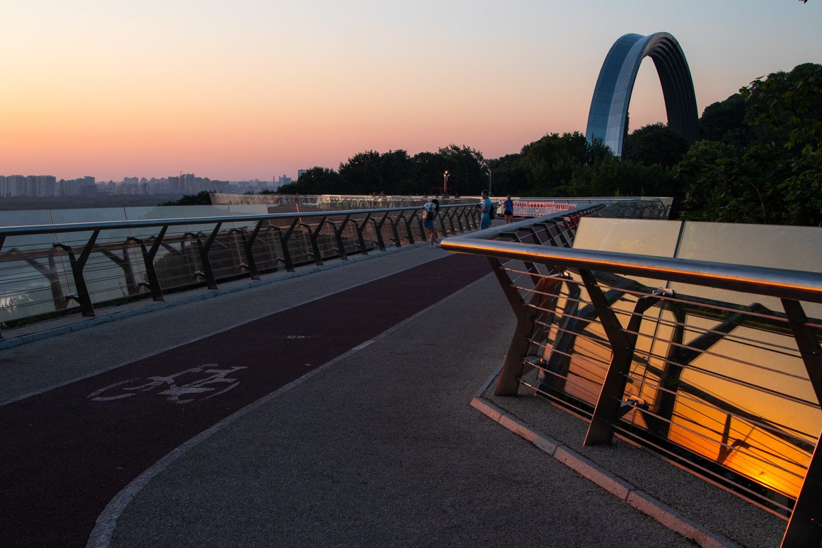 Лучи солнца пробиваются сквозь деревья и дома, с каждой минутой проблески становятся все ярче и ярче