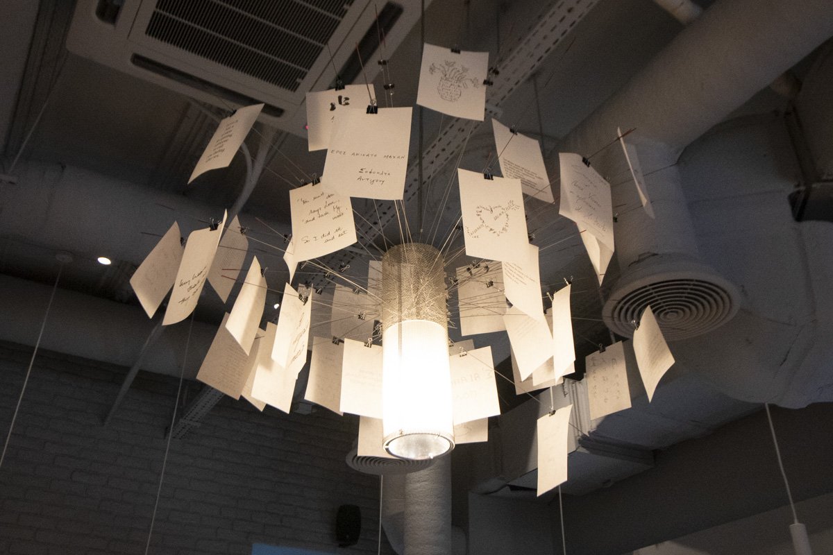 Потолок украшает люстра из записок на всех языках мира