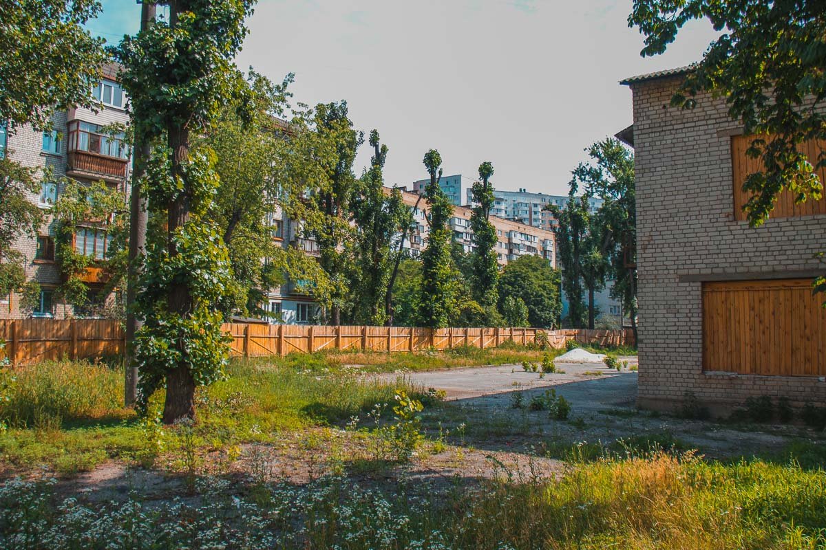 Территория заброшена, поросла сорняком и обнесена забором