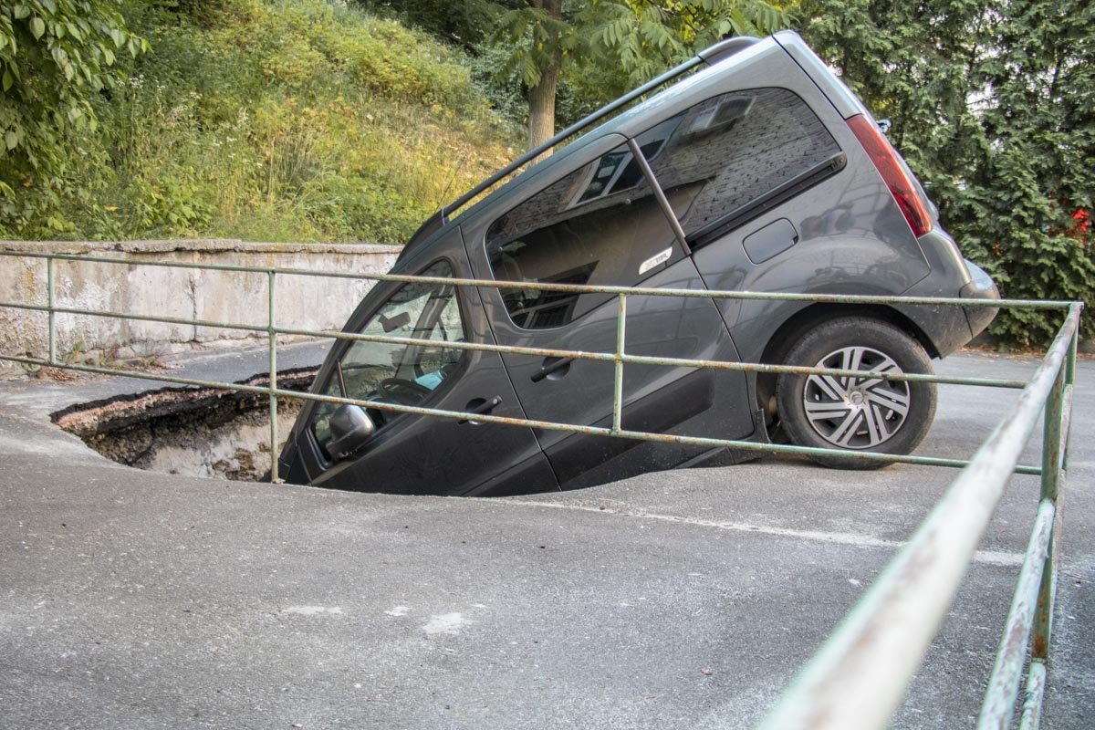 Машина оказалась наполовину в глубокой яме 