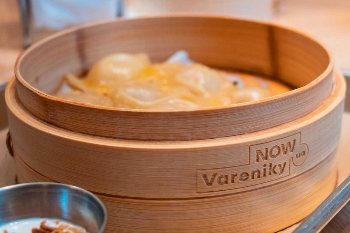 Все вареники подают в стильных деревянных корзинках, а дополняет их сметана с шкварками из лука 