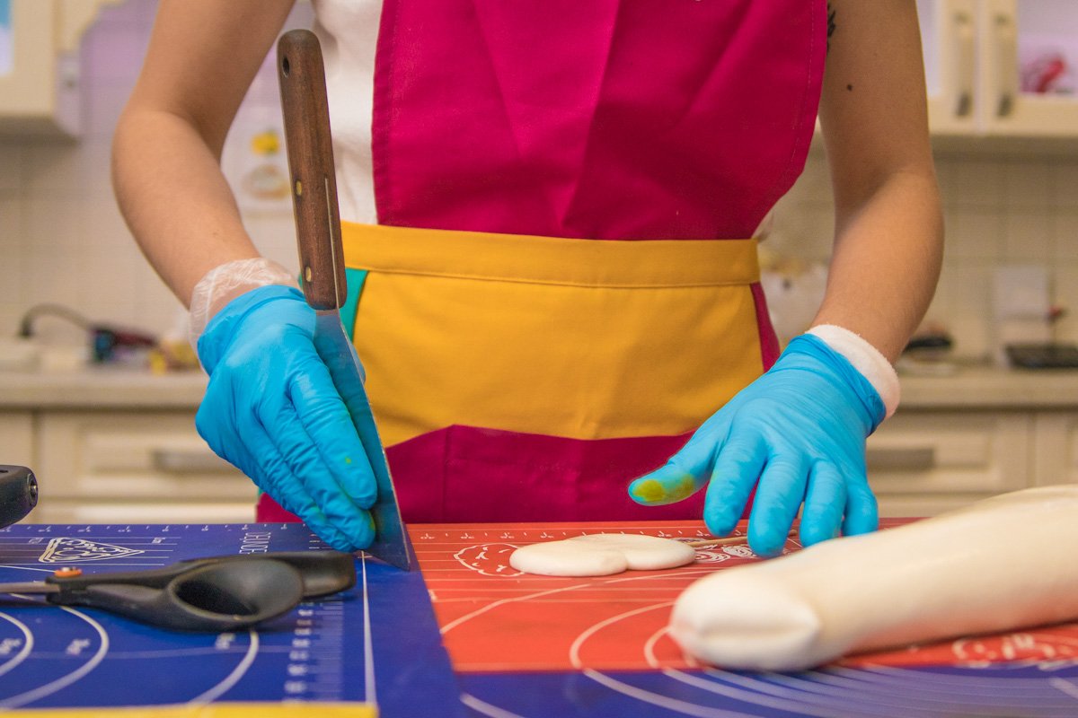 Мастер шпателем аккуратно выравнивает края и придает конфете нужную форму Мастер шпателем аккуратно выравнивает края и придает конфете нужную форму