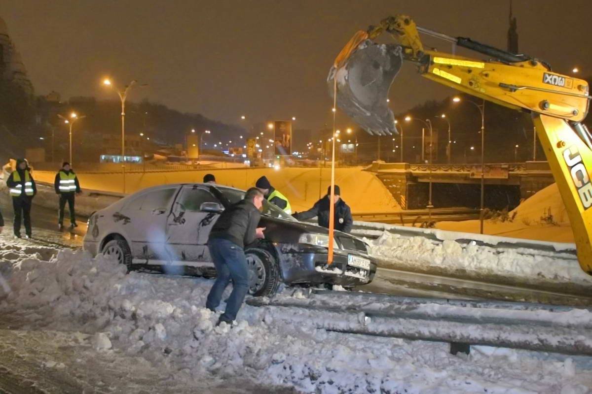 Машину "стащили" с помощью экскаватора, расчищающего рядом дорогу от снега Машину стащили с помощью экскаватора, расчищающего рядом дорогу от снега