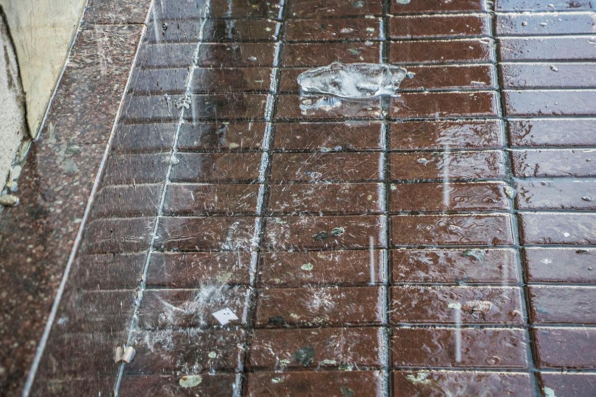 Маленькие льдинки лежат на асфальте, пока тоже не превратятся в воду 