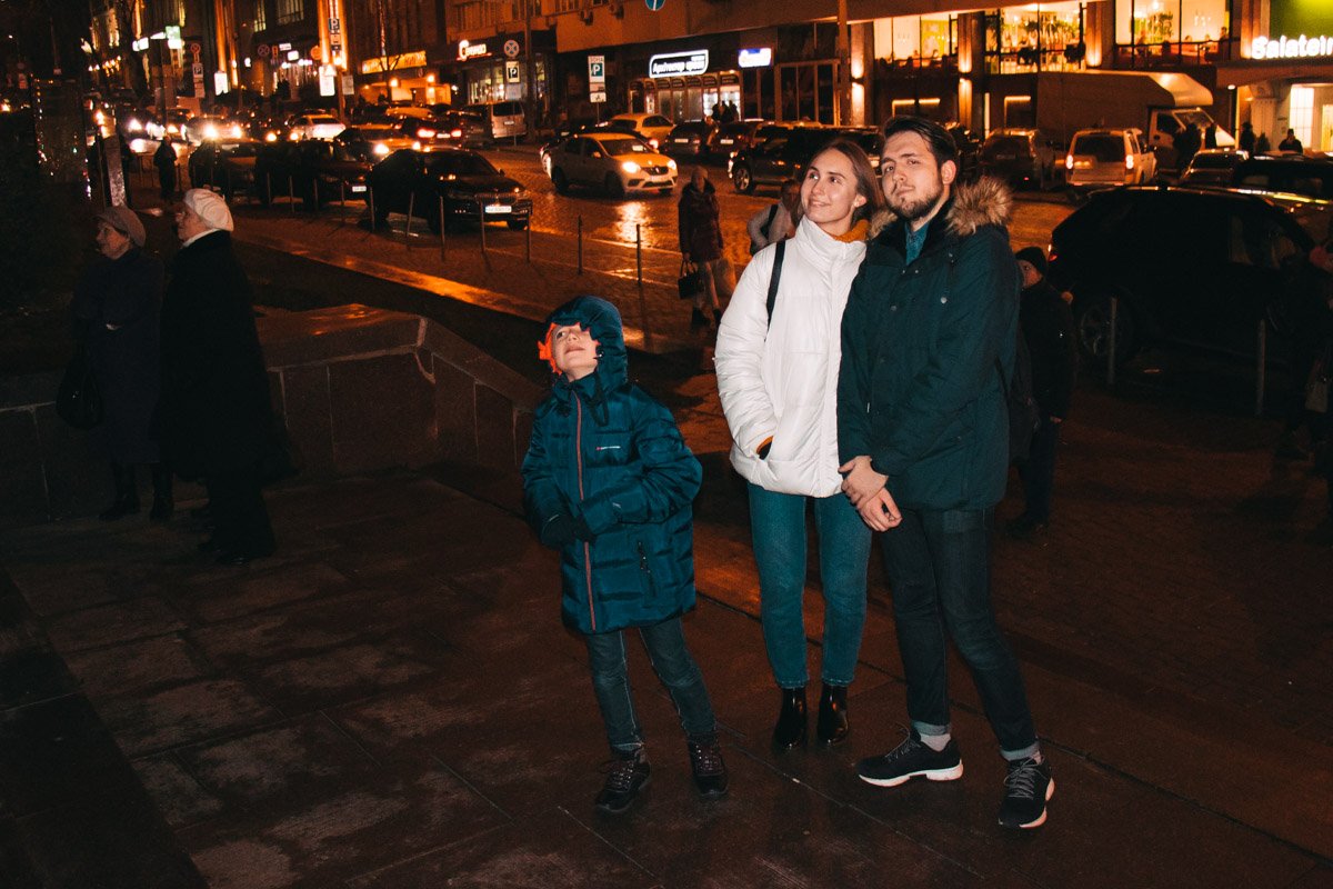 Прохожие останавливаются, чтобы посмотреть на проекции