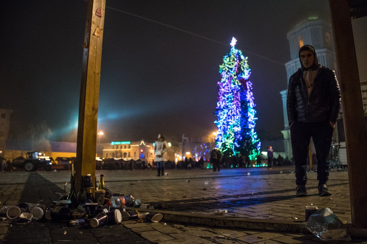 Мужчина, елка и стаканчики из-под глинтвейна 