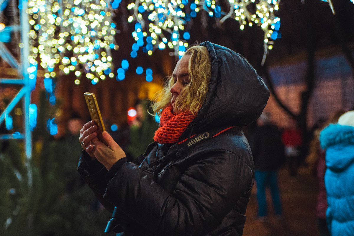 Люди спешат запечатлеть рождественские огни на камеру телефона Люди спешат запечатлеть рождественские огни на камеру телефона