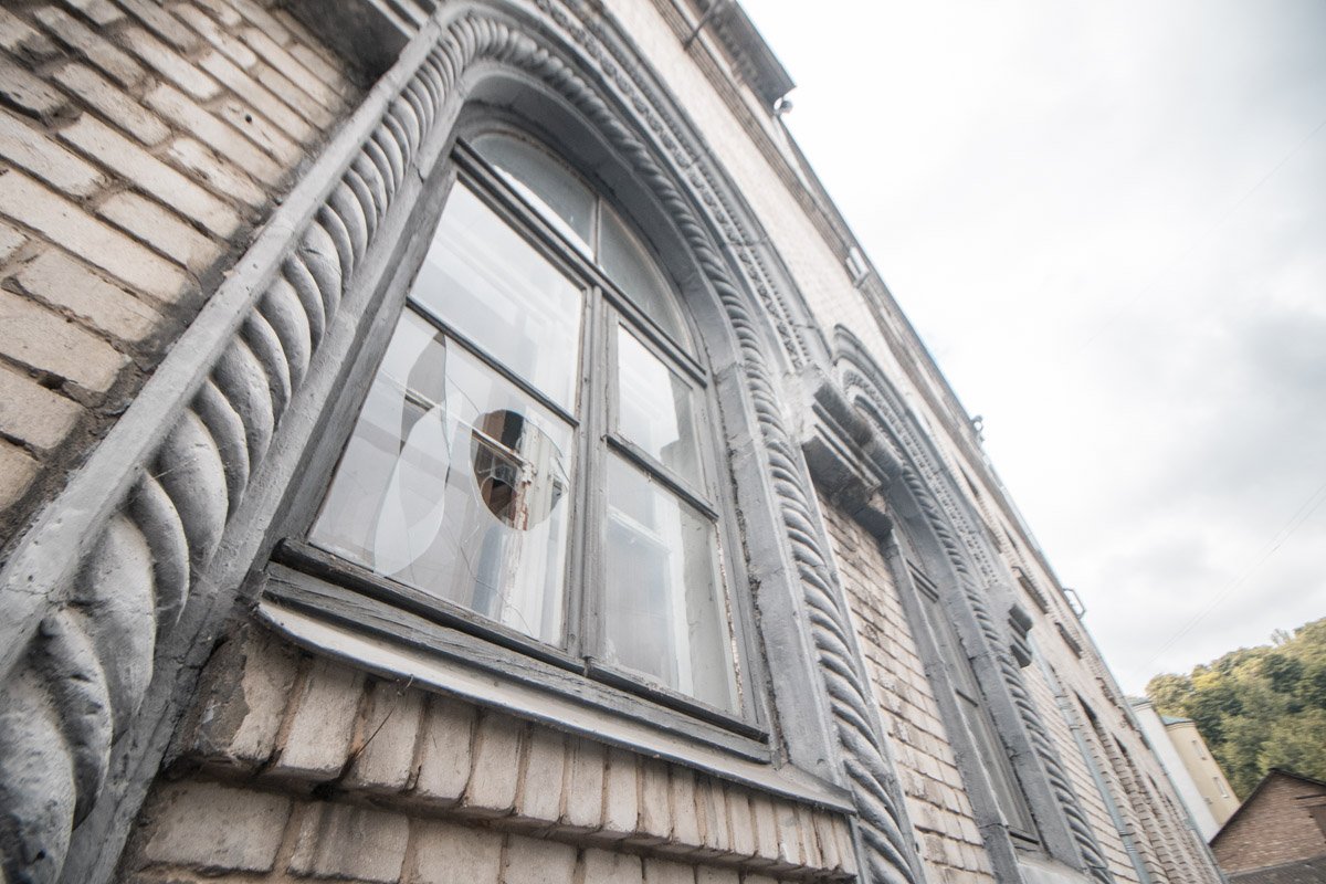 Но вот разбитые окна выдают заброшенность здания