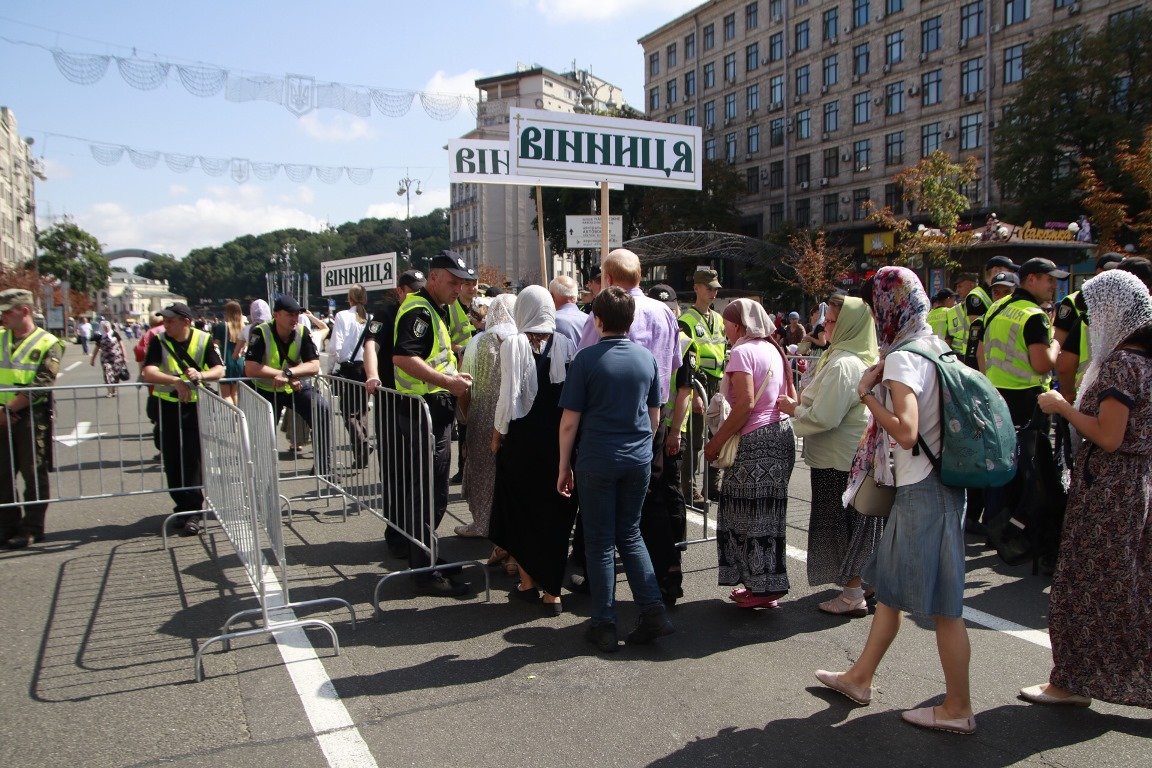 Пешеходов, которые хотят пройти через ограждение, проверяют с помощью металлоискателя и проверяют у них содержимое сумок