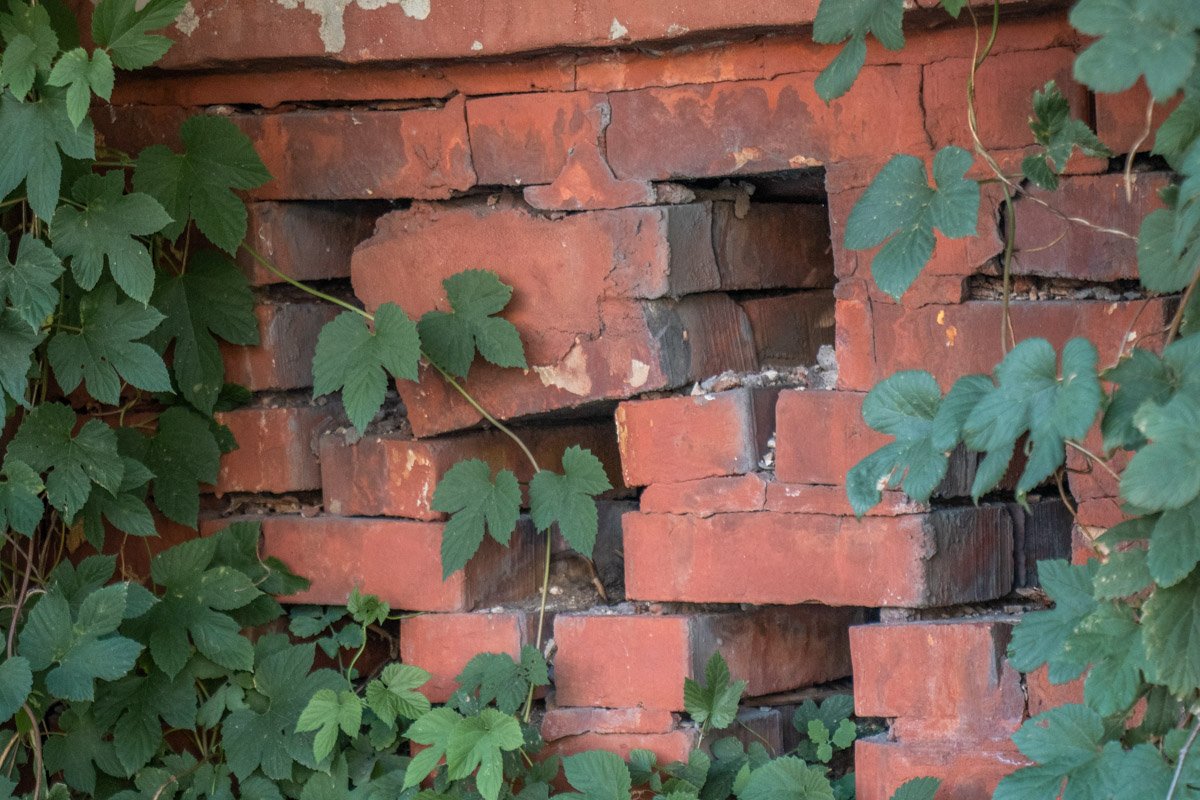 Кое где осыпавшиеся кирпичи привели вот к такому просевшему участку забора