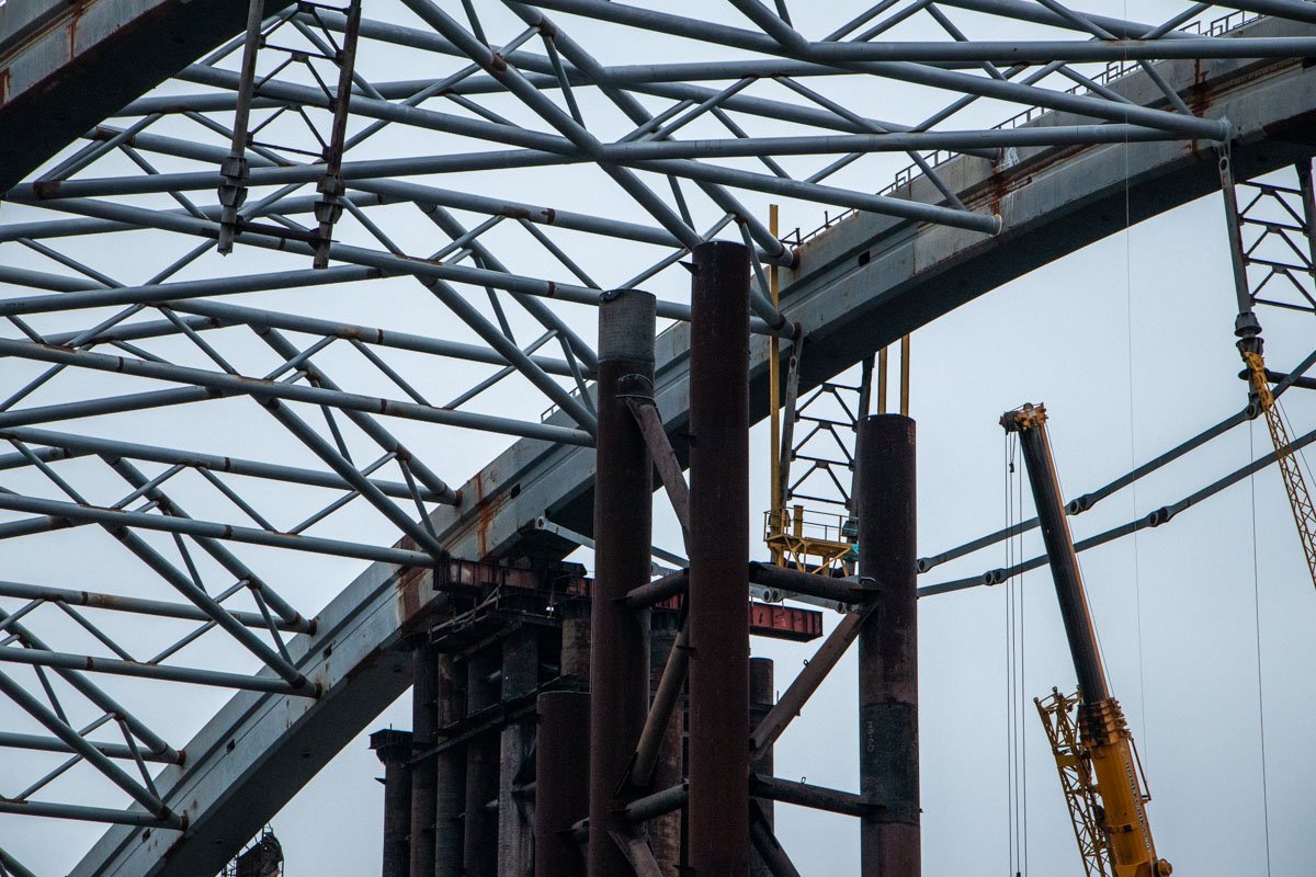 Строители разбирают железные конструкции Строители разбирают железные конструкции