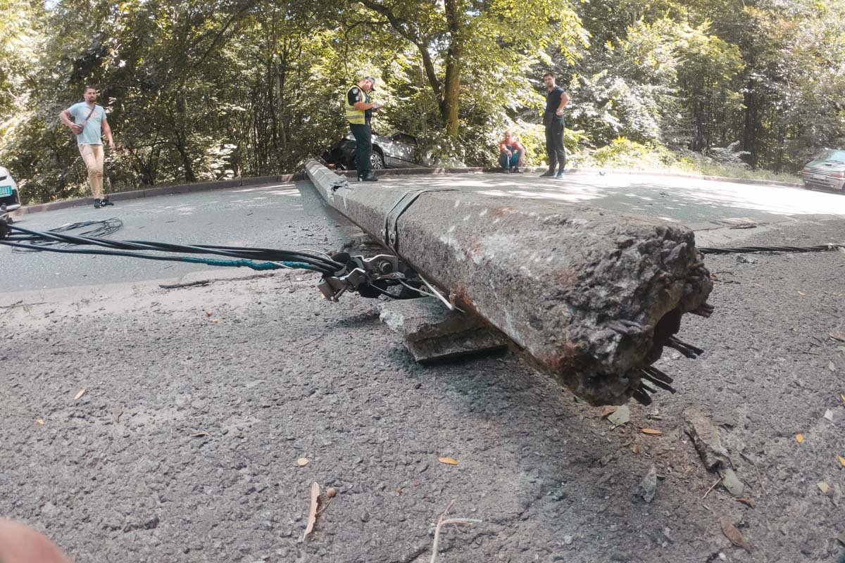 От удара столб упал и перегородил проезжую часть, а машины повисла на склоне