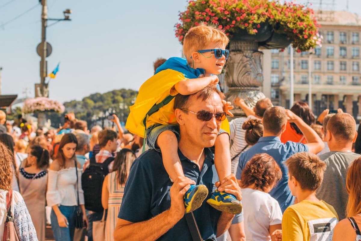 Малыши гуляли, сидя на плечах у родителей и спустив ножки