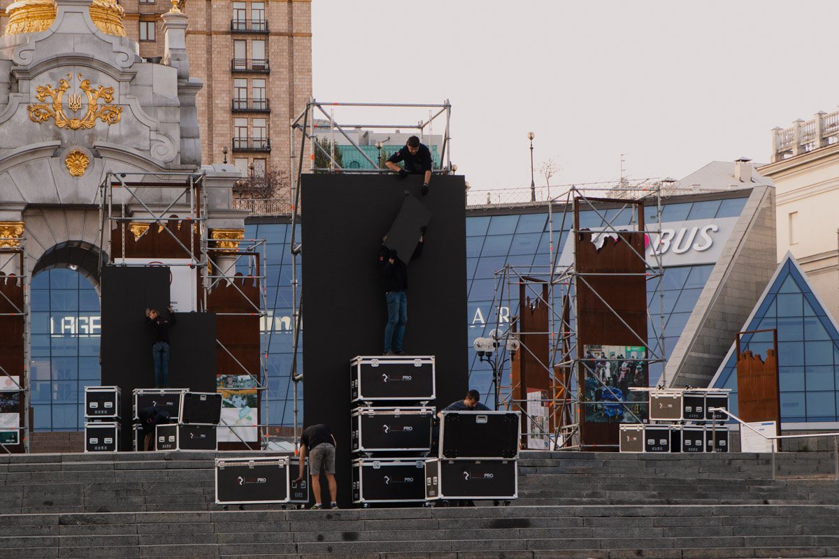 Уже при свете солнца рабочие продолжают разбирать праздничный реквизит