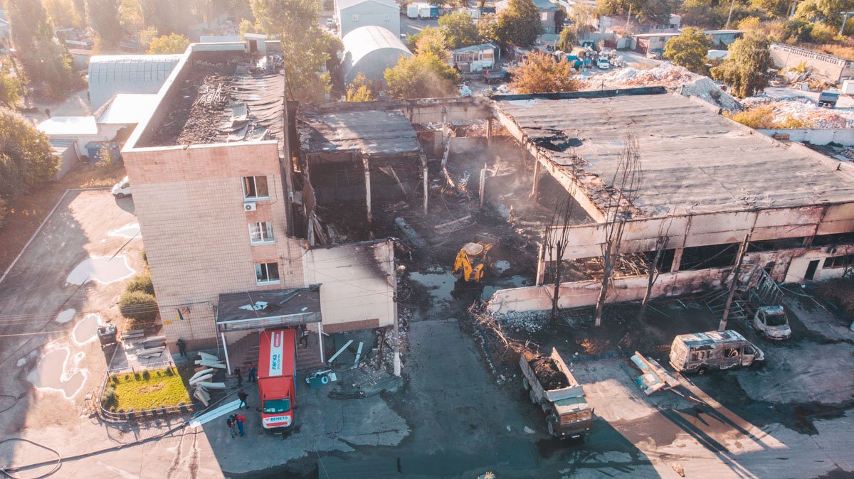 Трактор разбирает сгоревший склад 