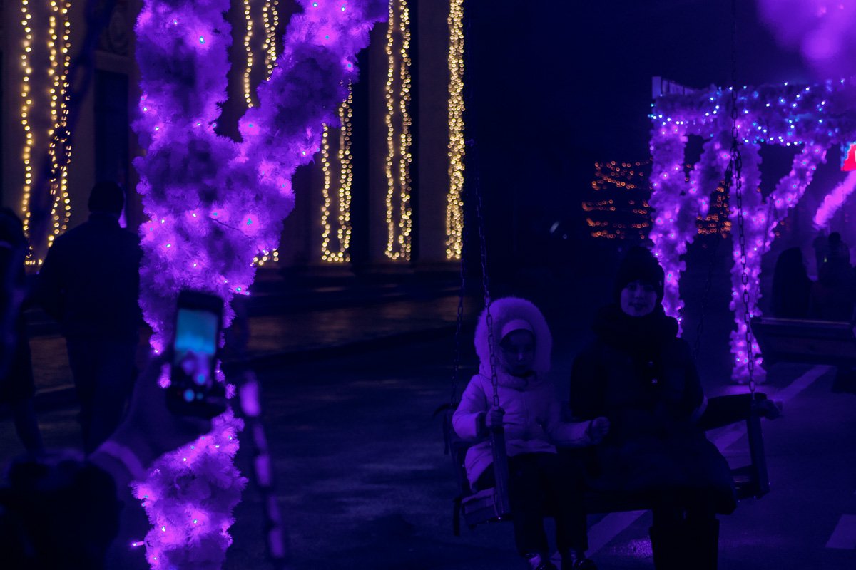 На территории качельки, и они все заняты даже поздним вечером, даже в холод 