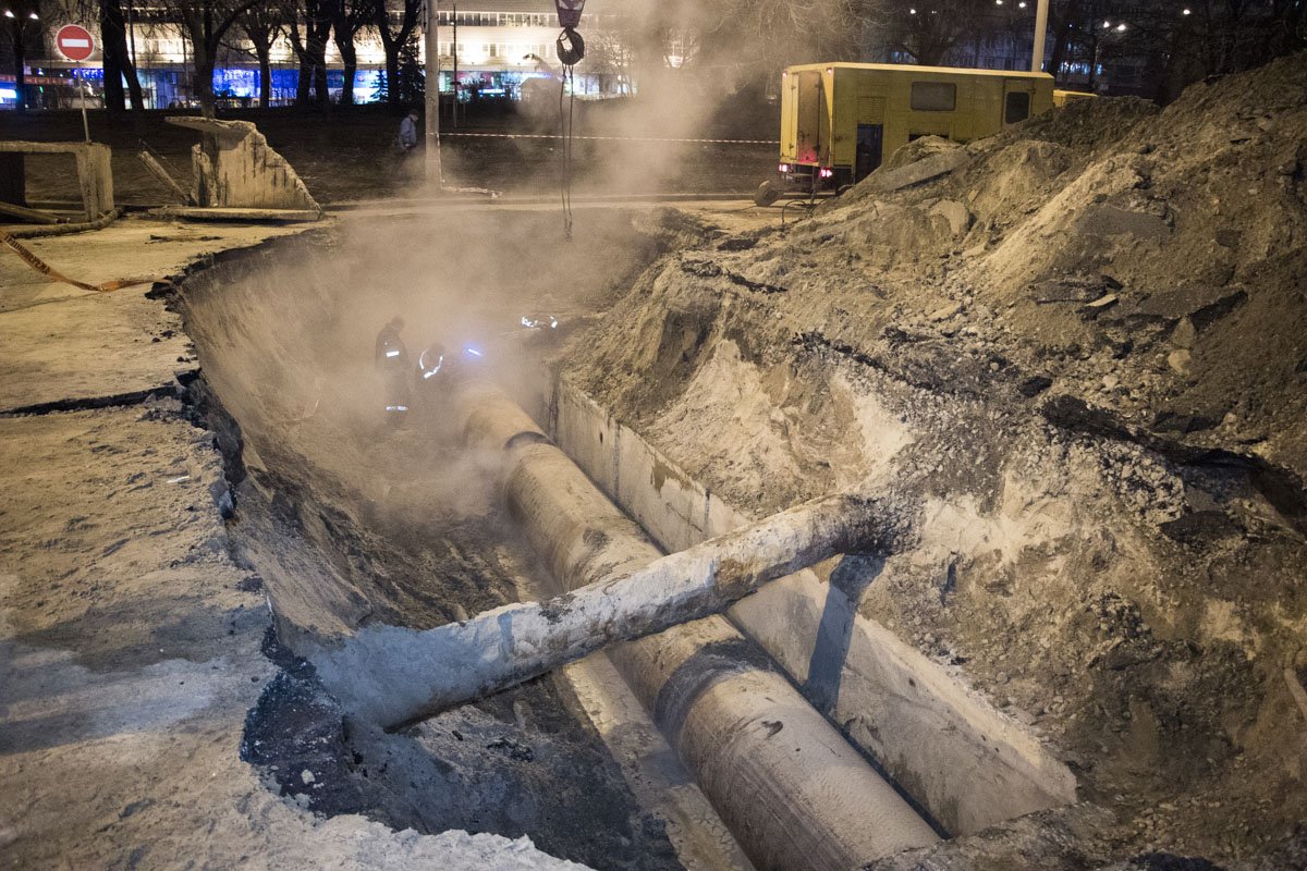 Сотрудники «Киевтеплоэнерго» полностью разрыли яму, где расположена теплотрасса, и разрезают трубу, чтобы достать ее по частям