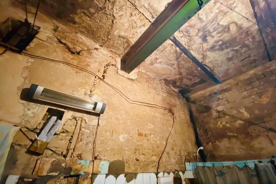 В большинстве камер изолятора недостаточно освещения, окна слишком зарешечены, стены в некоторых из них влажные и покрытые грибком В большинстве камер изолятора недостаточно освещения, окна слишком зарешечены, стены в некоторых из них влажные и покрытые грибком