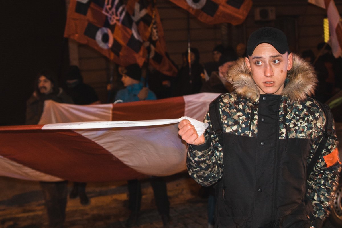 Участники марша несут флаг Беларуси