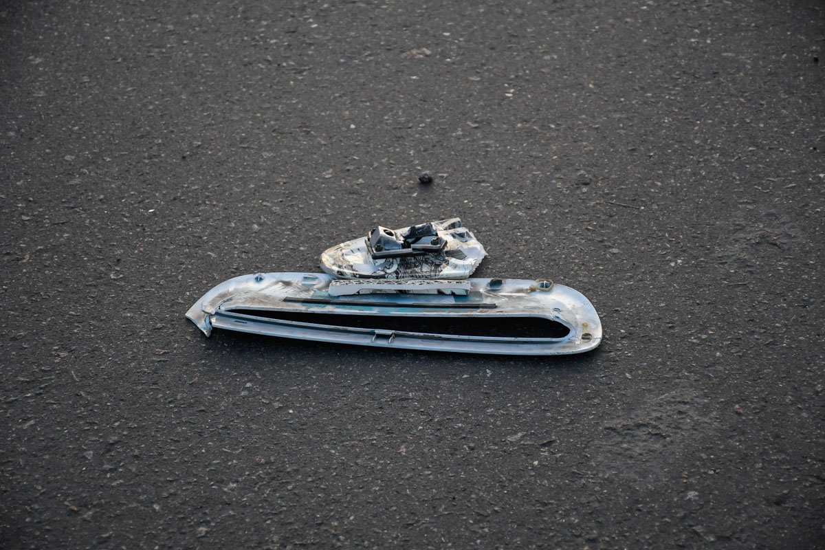 Дорога усеяна обломками скейта и деталями автомобиля Дорога усеяна обломками скейта и деталями автомобиля