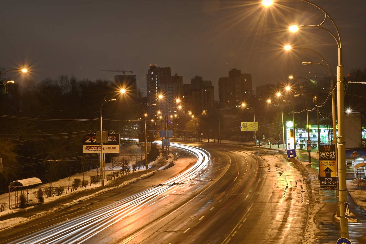 Пустынная автомагистраль, где только ночной свет фонарей летит на высокой скорости 