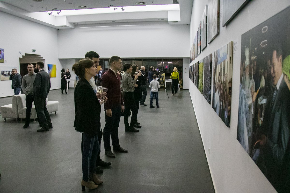 Неспешно попивая вино и заедая канапе, публика рассматривала фото