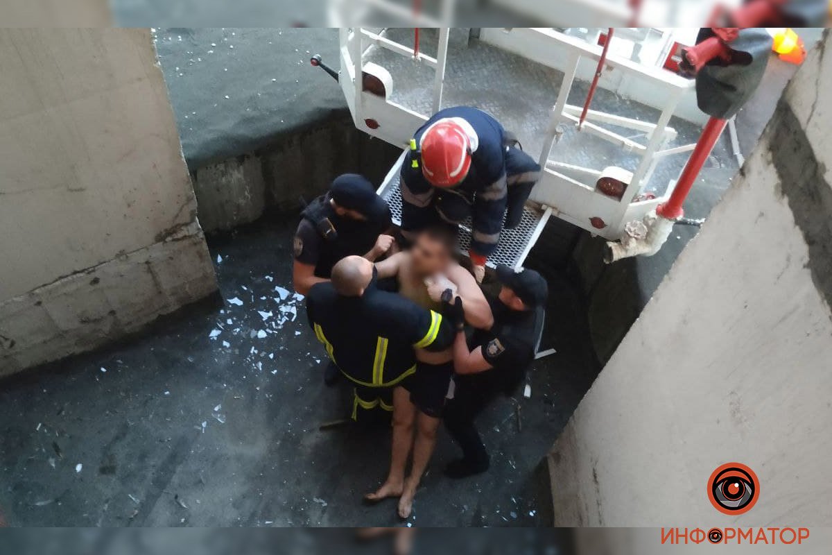 В Киеве неадекватный мужчина выбил окно, выпрыгнул с 5 этажа, упал на козырек дома и выжил: его доставали спасатели 20