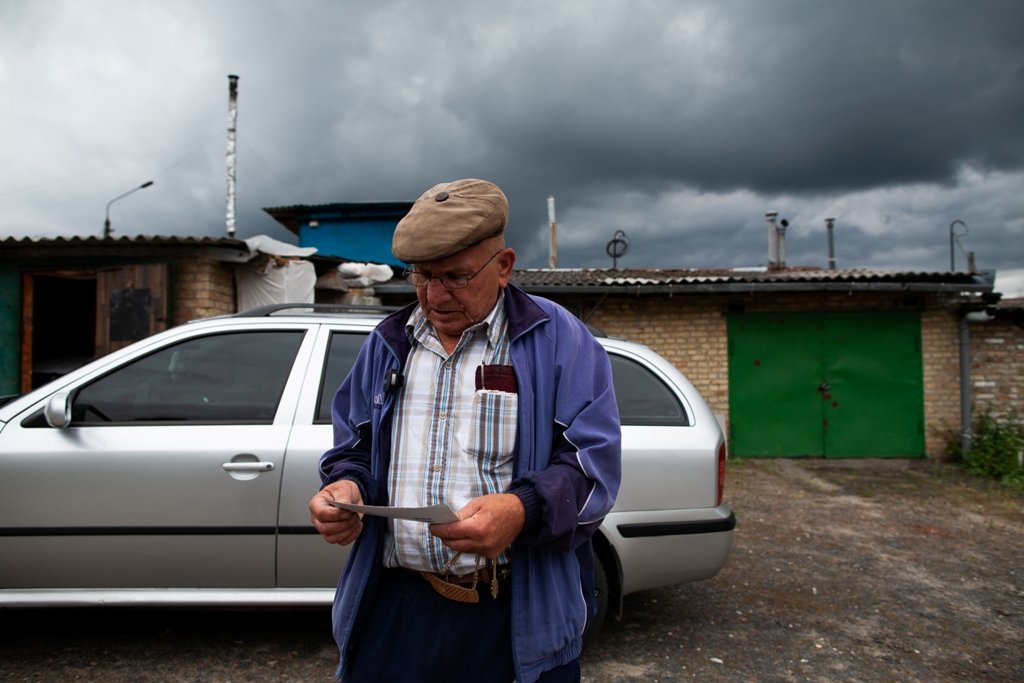 Іван Іванович перед показом своїх квартир дивиться на роздрукований знімок квартири, зроблений з дрону