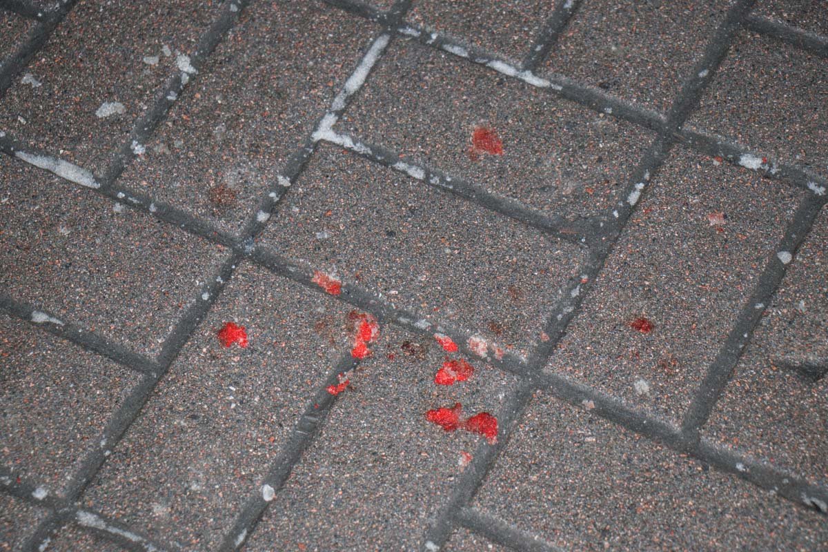 На тротуаре и ступеньках видна кровь