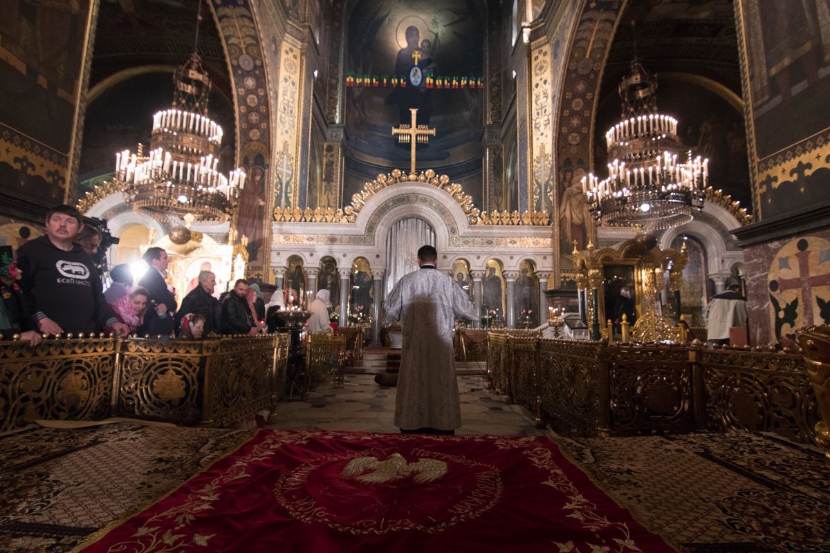 Люди слушают молитвы священника