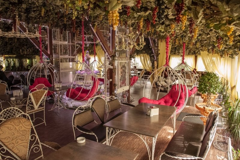 Впечатляющий интерьер в стиле летнего сада с розовыми подвесными креслами