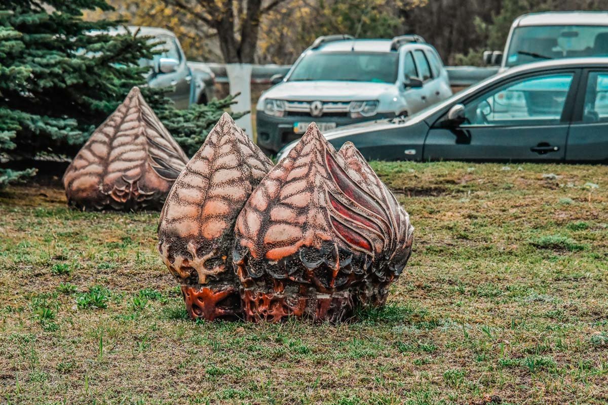 Возле саркофага стоят современные арт-объекты