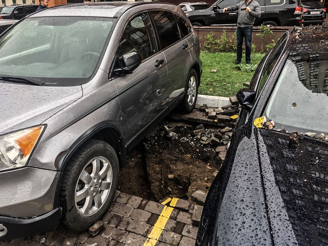 Части земли асфальта и плитки лежат на авто Части земли асфальта и плитки лежат на авто