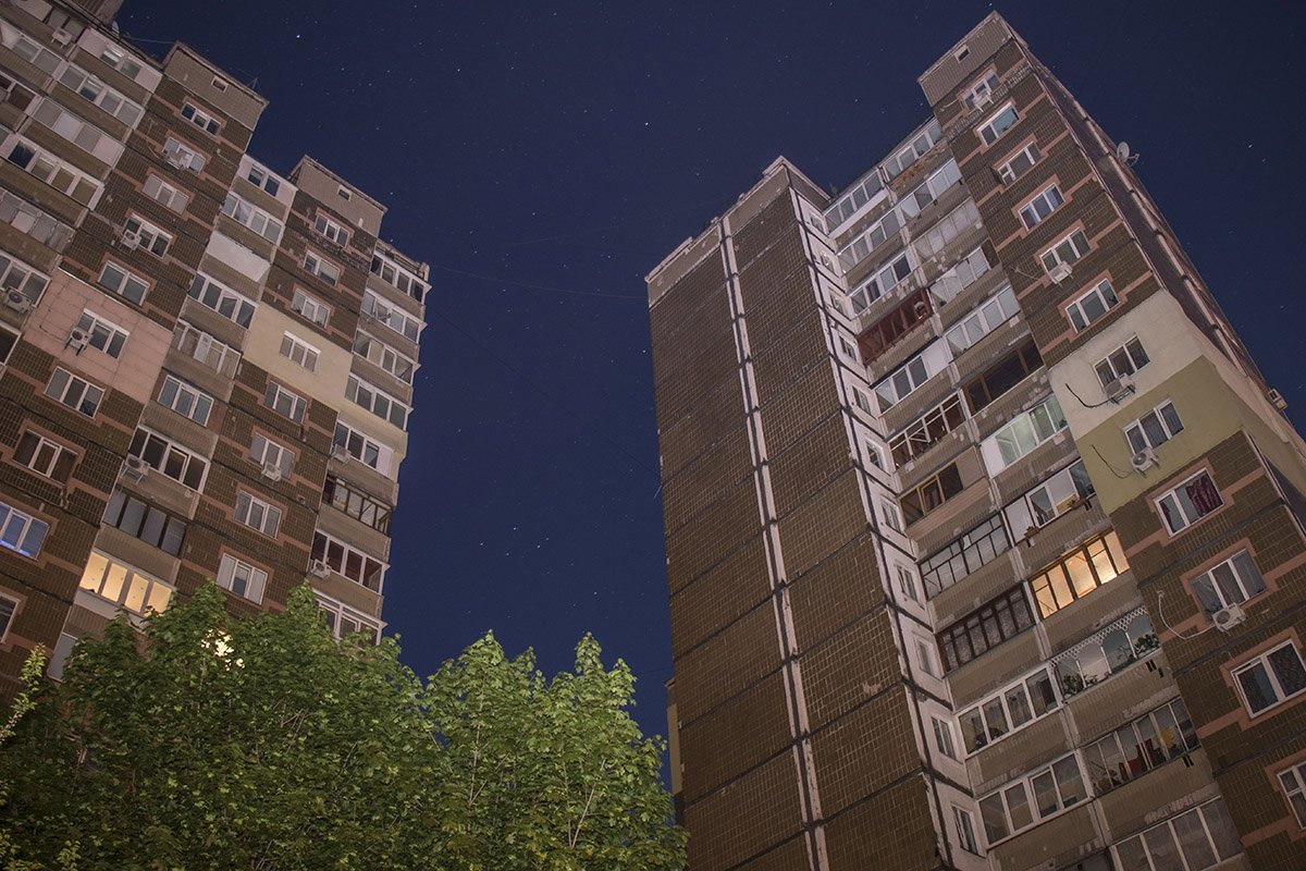 Дома под покровом ночи возвышаются над районом