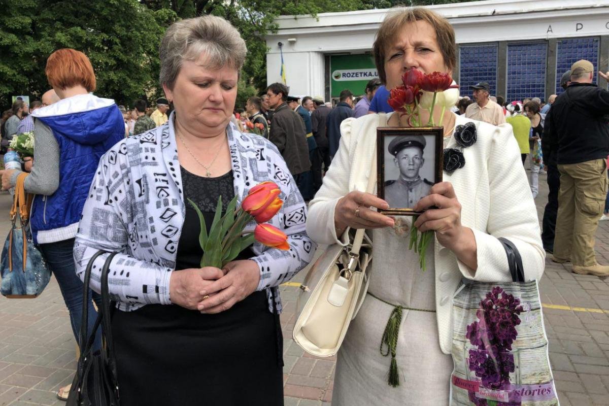 Пришедшие люди держат в руках фото своих родственников