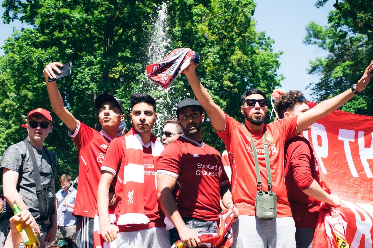 Фанаты в красных футболках размахивают футбольной атрибутикой