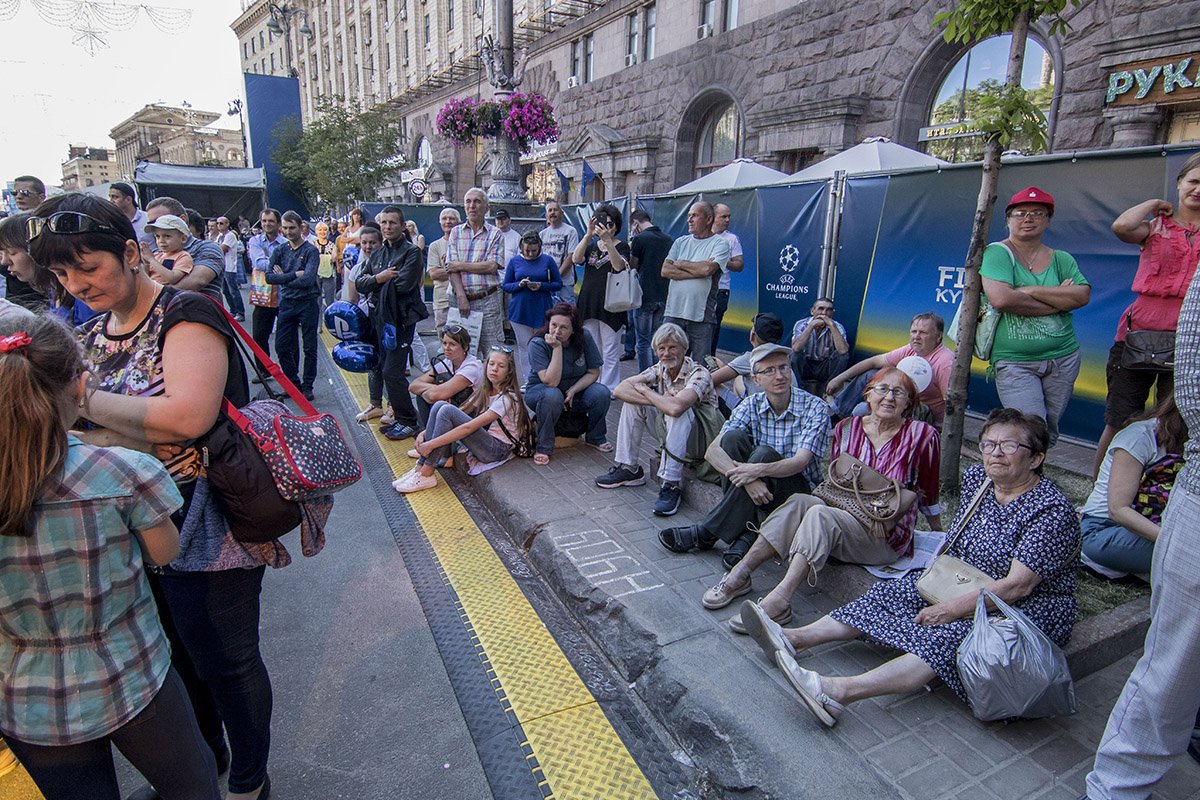 Уставшие зрители смотрели, сидя на обочине