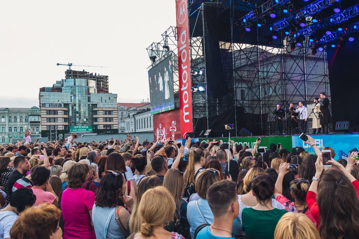 Люди под сценой наслаждаются мероприятием - танцуют, подпевают Люди под сценой наслаждаются мероприятием - танцуют, подпевают