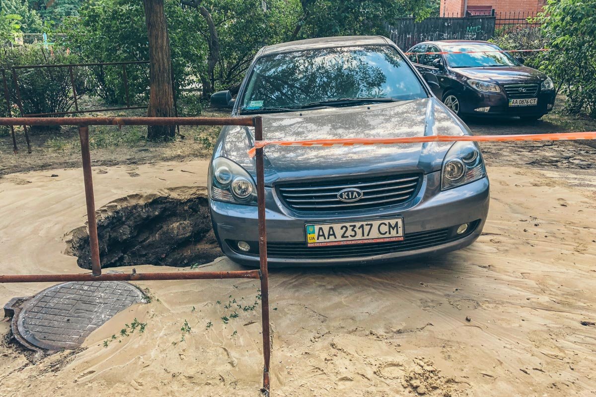 Автомобиль, припаркованный рядом, повис над 2-метровой ямой