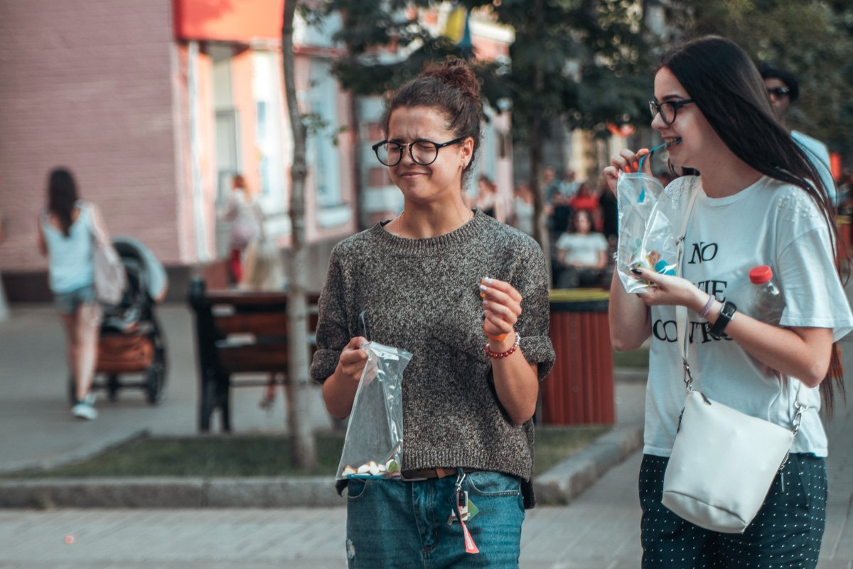 Девушки дегустируют что-то в целлофановых пакетах, и похоже одной из них это не очень нравится