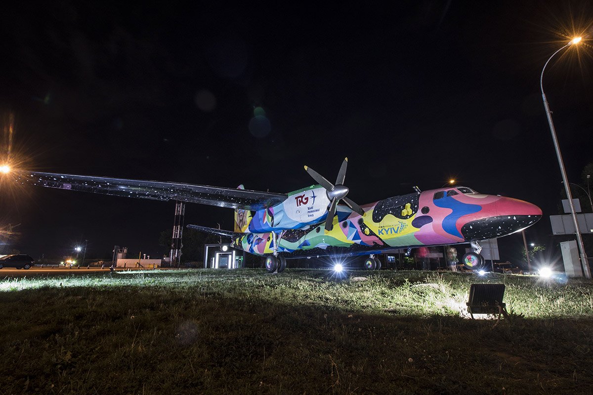 Яркий самолет в свете фонарей переливается новыми красками 