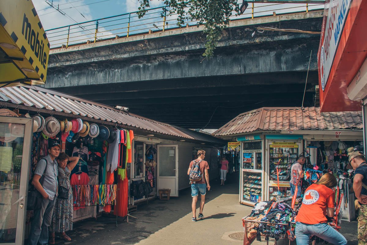 По всей видимости, продавцов одежды не смущает аварийный мост, нависающий у них на головами 